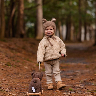 Toddler with pull-along in forest