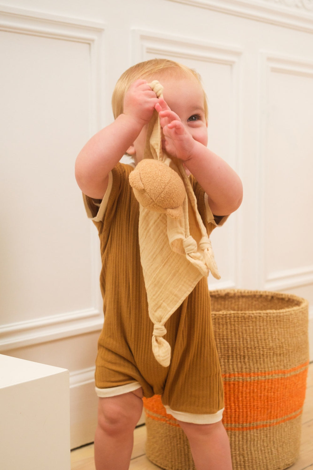 Baby holding Marcel bear doudou