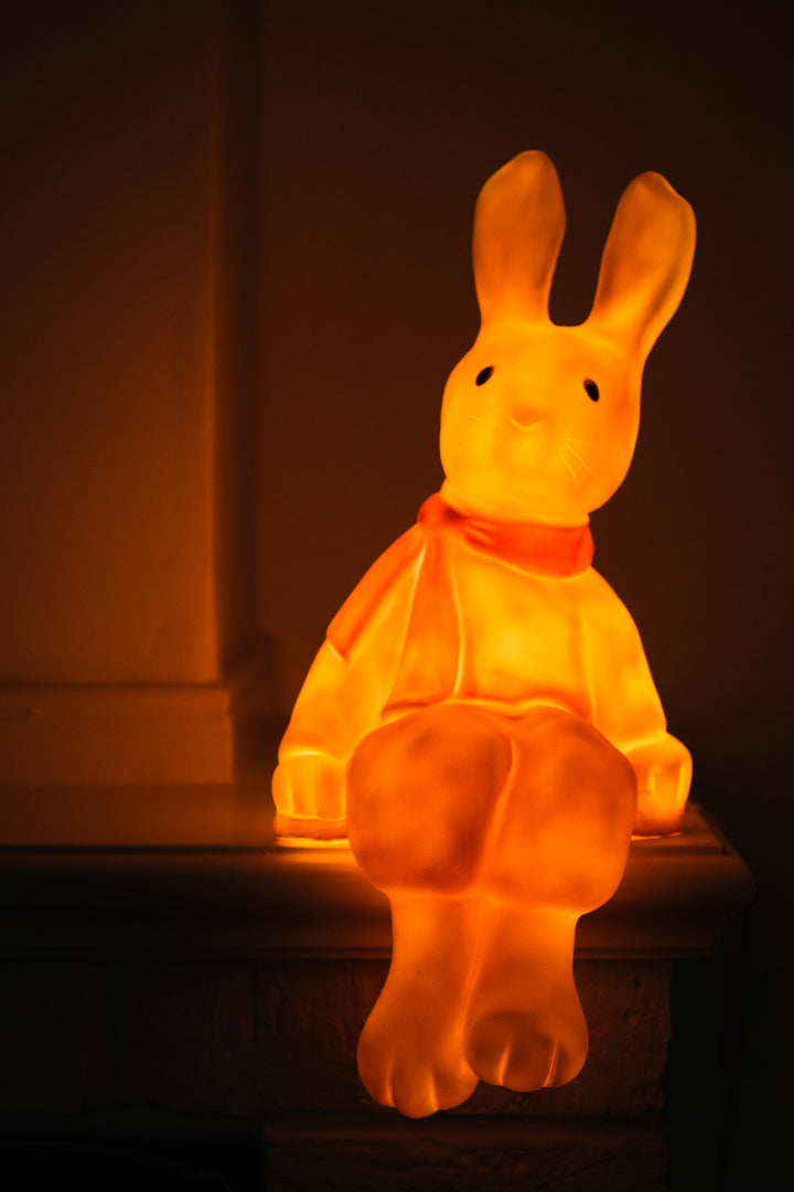 Lenny the Rabbit night lamp glowing on a mantle in the dark