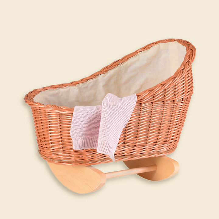Wicker doll cradle with knitted blanket