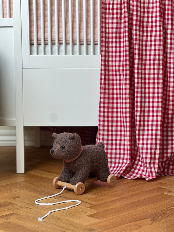 Raoul the pull-along bear next to a bed